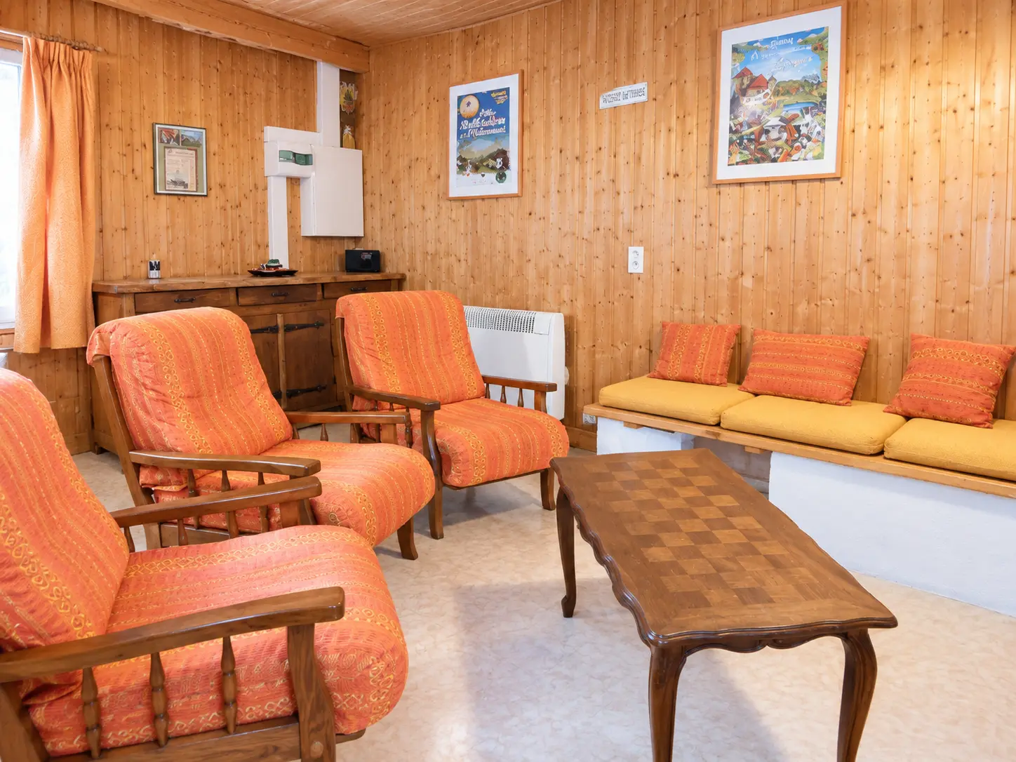 Coin salon avec cheminée et banquette du gîte Les Augets