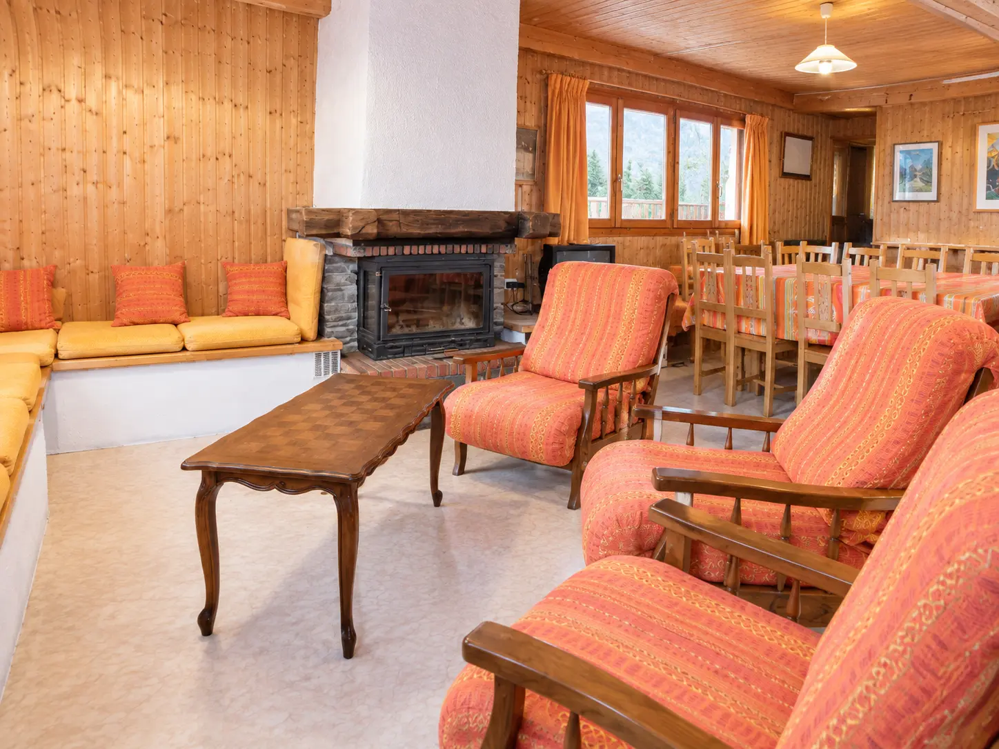 Salon avec cheminée à cassette et canapé du gîte Les Augets